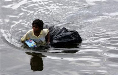 A young man walks through chest deep flood water after looting a grocery store in New Orleans