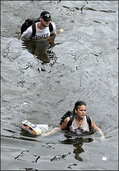 Two residents wade through chest-deep water after finding bread and soda from a local grocery store after Hurricane Katrina came through the area in New Orleans
