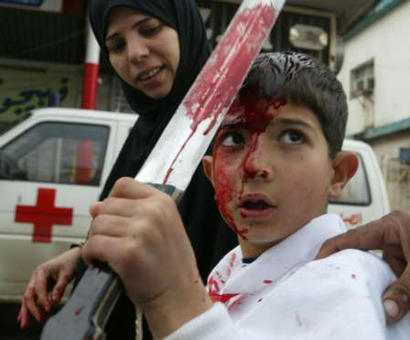 A Lebanese Shi'ite Muslim mother helps her son beat himself with a sword during a ceremony of Ashoura held in Nabatiyeh, March 13, 2003. Shiites in Lebanon commemorate the killing of Imam Hussein, grandson of the Prophet Mohammed, by his rival over 1,400 years ago. More than 150,000 Lebanese packed the streets of Beirut's southern suburbs on Thursday, chanting 'Death to America,death to Israel,' in a mass rally called by Lebanon's Hizbollah guerrilla group.